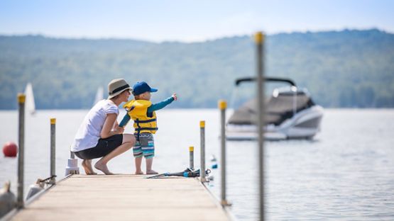 A young boy and his mother enjoying the lake view at the end of the dock.